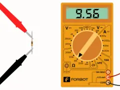 Multimetr mierzy opór elektryczny rezystora. Na wyświetlaczu 9.56, pokrętło ustawione na pomiar omów.