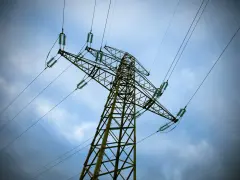 Wysoki słup energetyczny z przewodami pod napięciem, zapowiedź PGE planowe wyłączenie prądu.