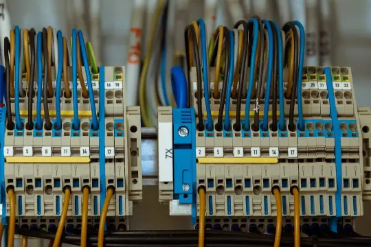 Zaciski elektryczne z kolorowymi przewodami tworzą skomplikowane przyłącze energetyczne.