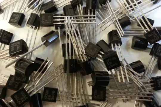 Stos małych, czarnych elementów elektronicznych, każdy z trzema nóżkami. To popularne tranzystory 2N3905, gotowe do pracy w obwodach.