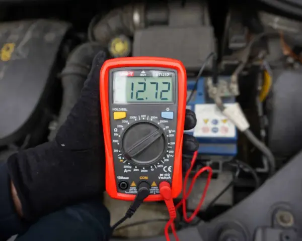 Sprawdzanie akumulatora miernikiem. Wynik 12.72V pokazuje, że jest naładowany.