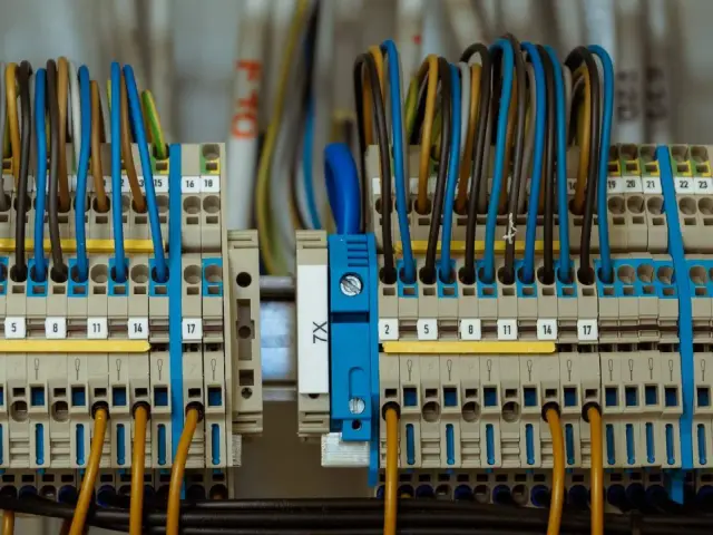 Zaciski elektryczne z kolorowymi przewodami tworzą skomplikowane przyłącze energetyczne.