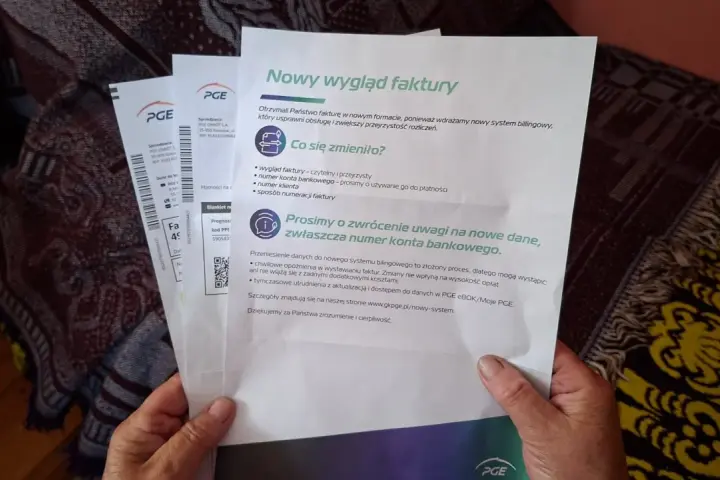 Dłonie trzymające dokumenty PGE z informacją o nowym wyglądzie faktury.