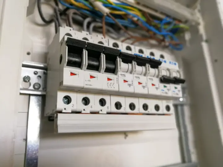 W rozdzielnicy elektrycznej widać rzędy bezpieczników automatycznych, każdy oznaczony numerem, np. c16.